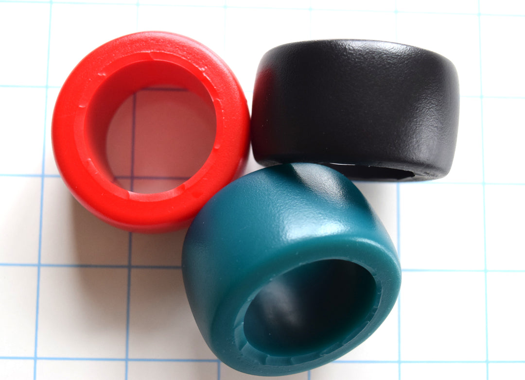 extra-large 1 5/16-inch inside diameter silicone stamina sensory ring, 1 3/32-inch wide, over 1/4-inch thick, available in multiple firmness levels and colors on a blue grid background.