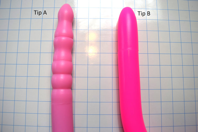 Comparison of Tip A and Tip B 1.6 inch silicone colon tube designs, showing pink tip A and fluorescent pink tip B, and  on a grid background