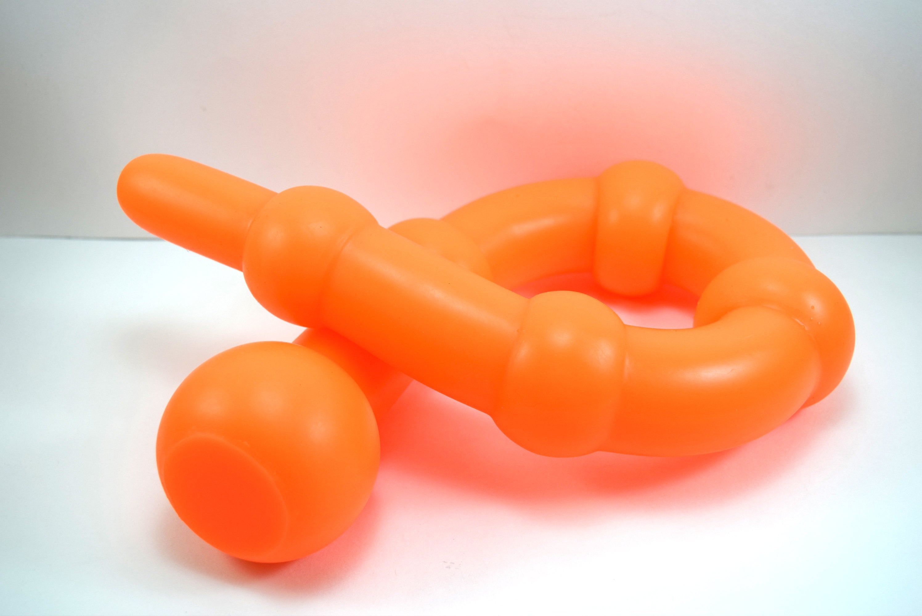 26 inch colon ball serpentine silicone enema nozzle coiled showing 2.5 inch sensory spheres and 3 inch safety ball flange.