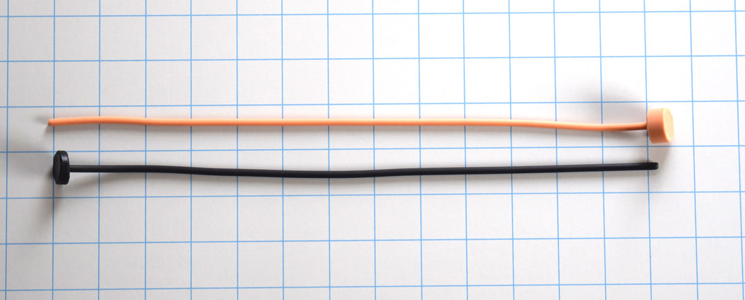 Two 4mm straight flexible silicone sounds—one black and one orange—displayed horizontally on a grid background with end caps.