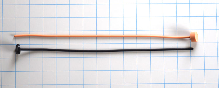 Two 4mm straight flexible silicone sounds—one black and one orange—displayed horizontally on a grid background with end caps.