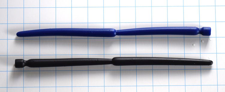 SSND-Double Expansion 12-inch advanced silicone urethral sound resting on a blue grid background, showcasing its dual 14mm and 13.7mm expansion nodes, 9mm tapered tip, and flared safety base.