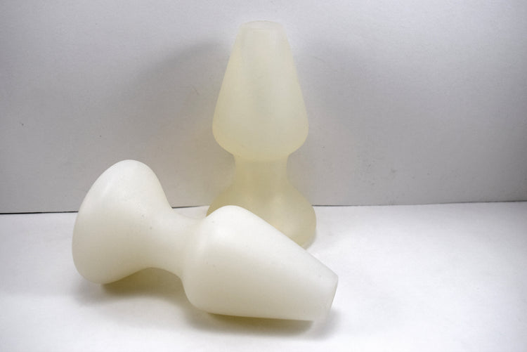 White and translucent silicone CSRE 2.5-inch rounded-edge colonic speculum retention enhancers, shown standing upright and lying flat on a light surface.