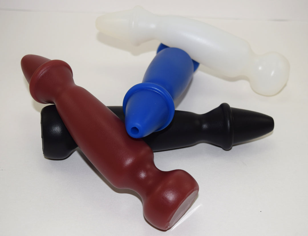 Four Bishop 8-inch silicone enema nozzles in brown, black, blue, and translucent white arranged in a cluster, featuring a tapered expanded ring tip and flanged base.