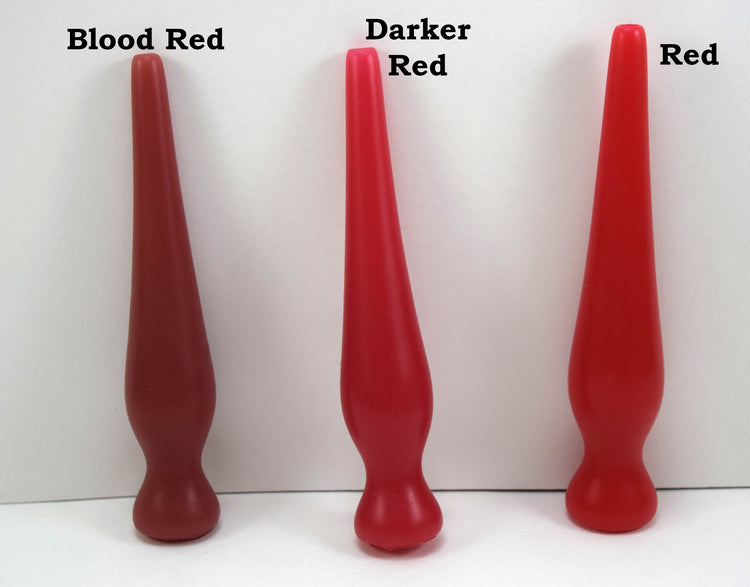 Three long silicone nozzle plugs displayed side-by-side on a white surface to demonstrate color variations. The plugs are labeled from left to right as 'Blood Red', 'Darker Red', and 'Red'; each features an elongated, tapered shape with a rounded base.