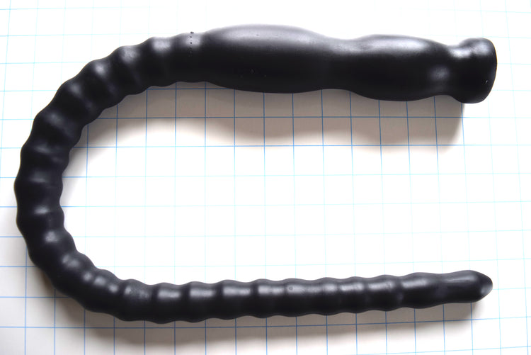 CT80-122 French 34-inch tapered ribbed colon tube in matte black silicone on a blue grid background, showing the shaft expanding from 1-inch to 1.6-inch diameter with 2.25-inch double retention balls.