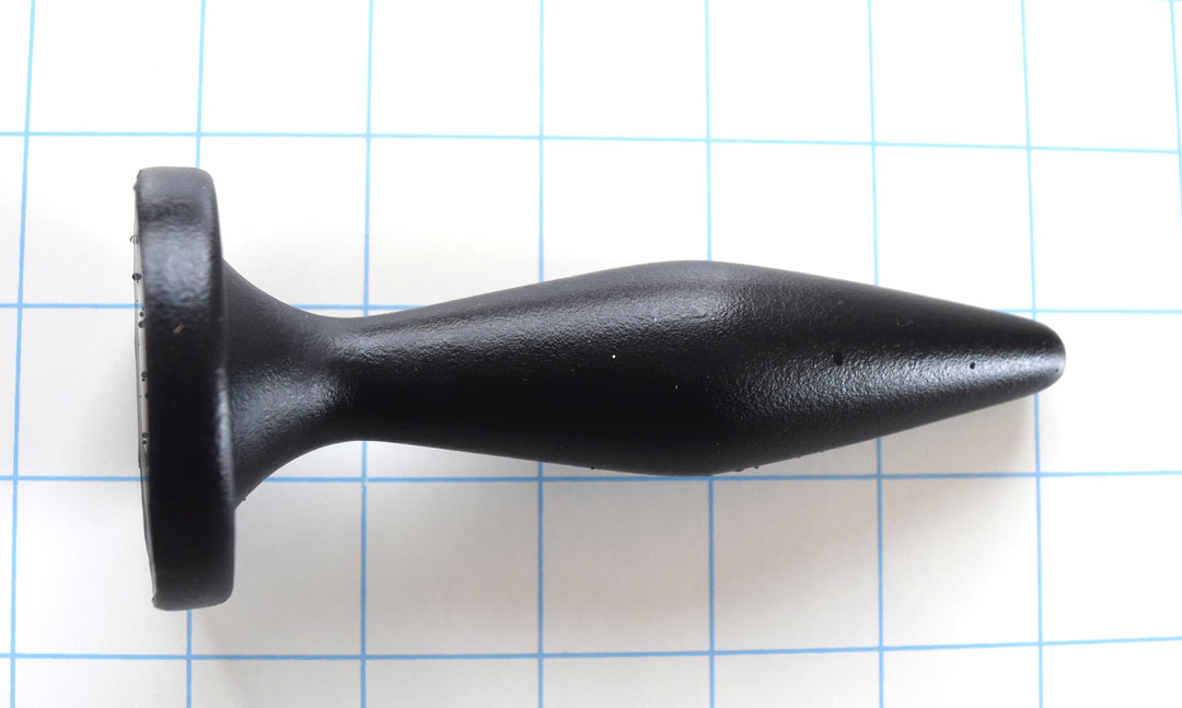 Black silicone Diamond Tip 5-inch nozzle and plug with a tapered, bulbous design and oval retention flange on a white grid background