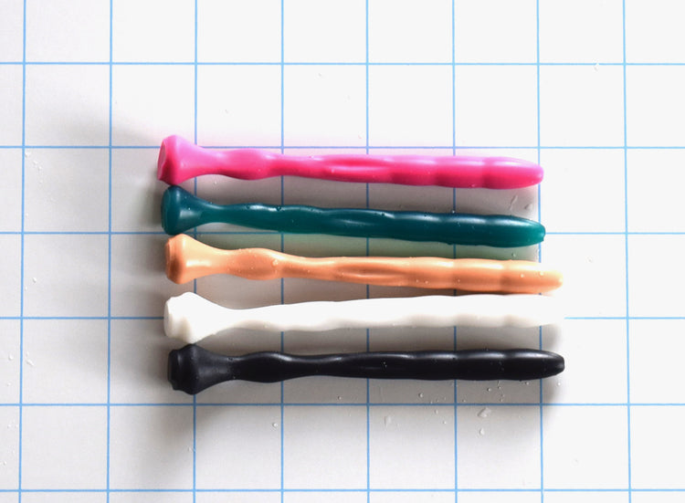 SSND-Dimpled short flexible silicone urethral sound shown in multiple colors on a grid background, highlighting its 5mm rounded tip, 9.25mm dimpled textured shaft, and a narrow 4.75mm flattened billow section leading to a 14.5mm safety base flange.
