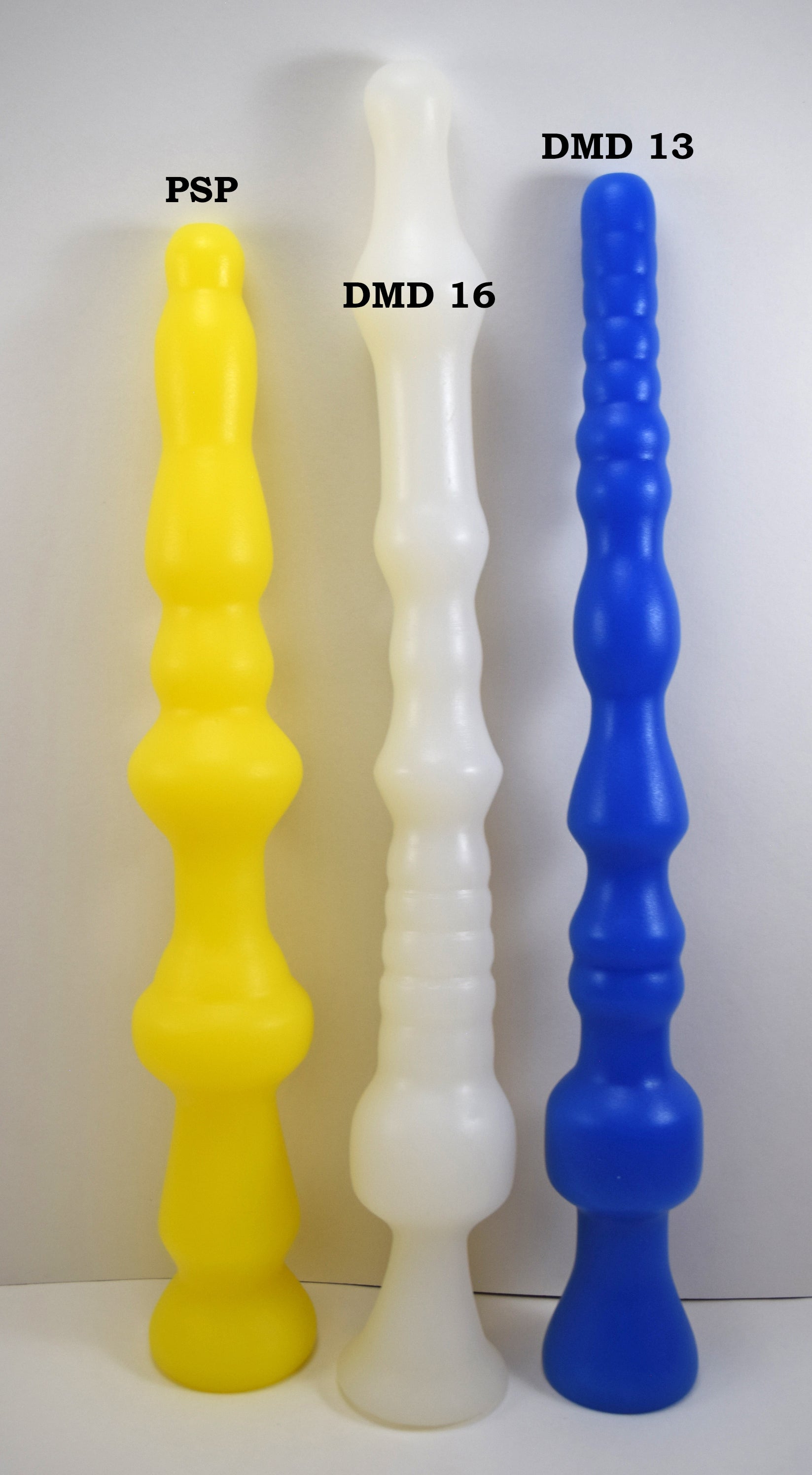 DMD 13 inch blue silicone enema retention nozzle shown side by side with PSP yellow nozzle and DMD 16 translucent white nozzle.