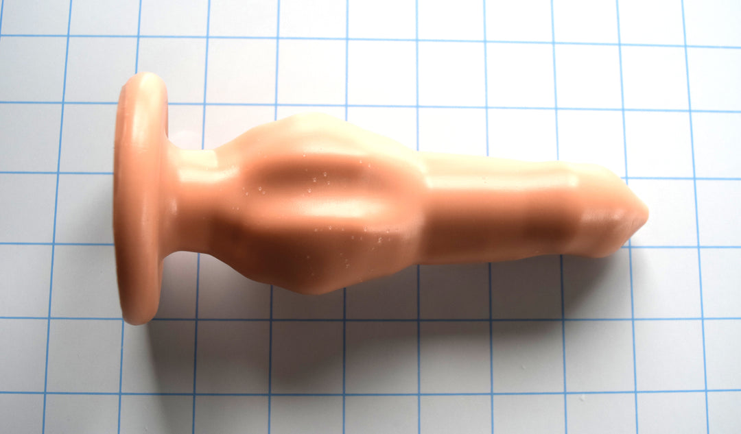 The Drake alien-style silicone nozzle with bio-organic curves, 6-inch insertable length, and large safety base flange on a white grid background
