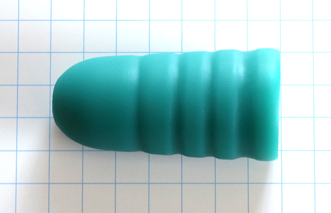 Overhead angle view of a green ESS 5 silicone stimulation sleeves showing their textured exterior valleys on a blue grid background.