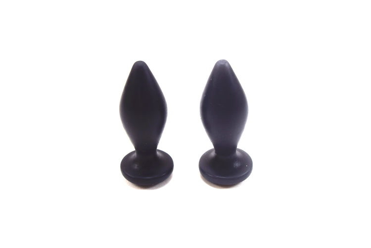 Pair of Expanded Diamond 1-inch black silicone retention nozzles showcasing their wide faceted diamond bodies, 2-inch insertable lengths, ultra-slim retention valleys, and flat safety flanges on a grid background.