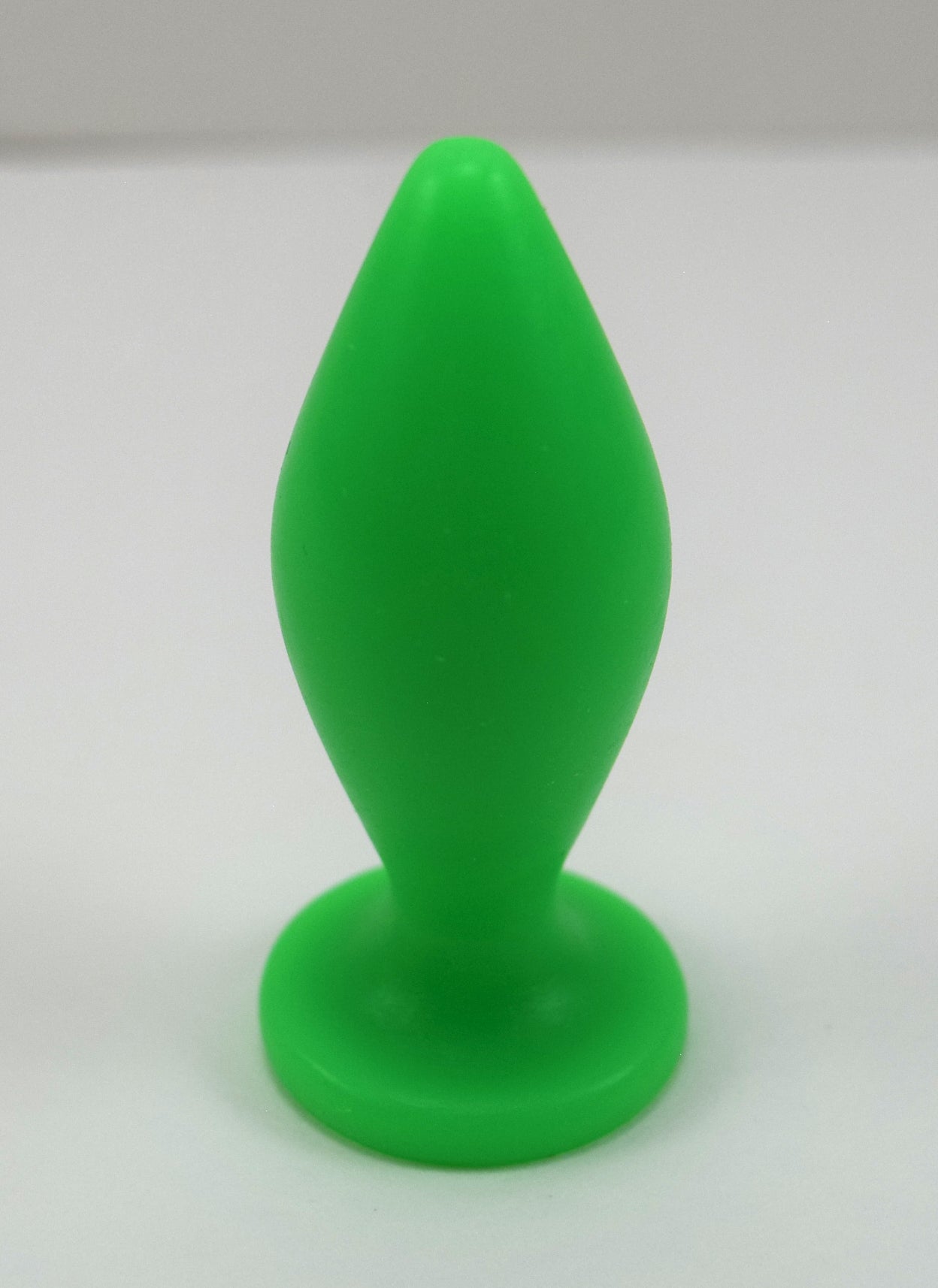 Expanded Diamond 1-inch fluorescent green silicone retention nozzle featuring a wide faceted diamond body, 2-inch insertable length, ultra-slim retention valley, and flat safety flange on a grid background.