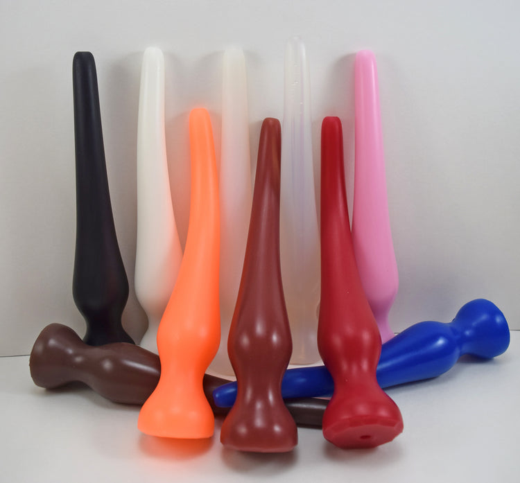 Multiple EXT CON 1.5 inch silicone enema retention nozzles displayed vertically in various solid and translucent colors.