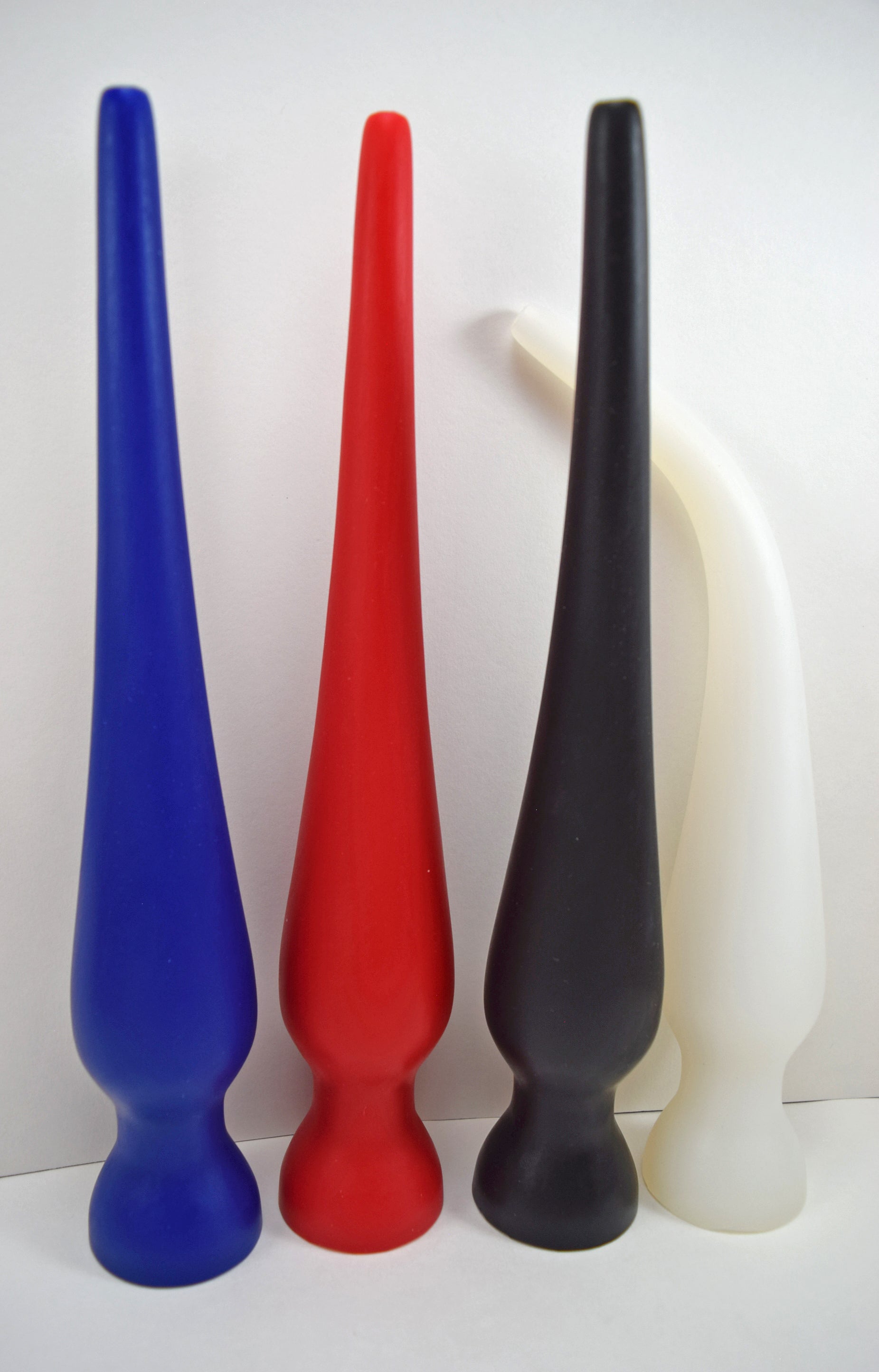 Vertical lineup of four EXT CON 2.0 inch silicone retention nozzles standing upright in blue, red, black, and translucent white.