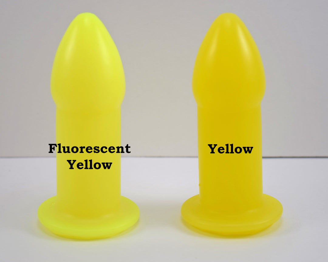 Two silicone nozzle plugs side-by-side on a white surface, demonstrating color differences. The plug on the left is labeled 'Fluorescent Yellow', and the plug on the right is labeled 'Yellow'; both have a tapered tip and wide safety flange