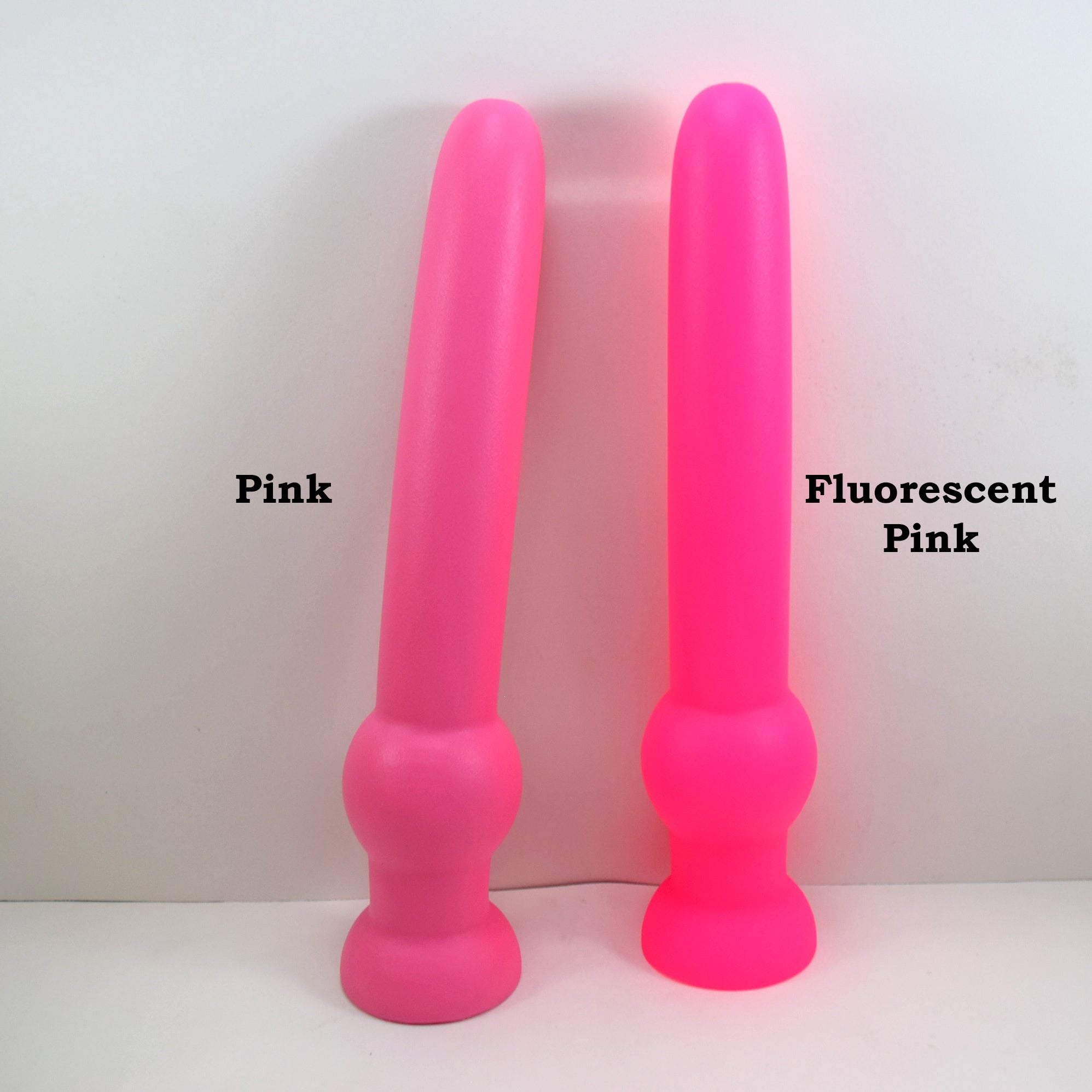 GRB 122 pink silicone colon nozzle showing its 11-inch insertable 1.6-inch diameter shaft, a 2.4-inch grip retention ball, and a flared safety flange on a grid background.
