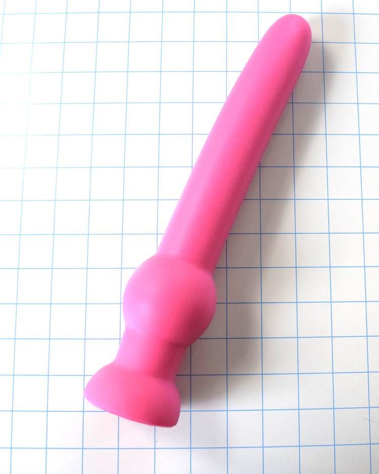 GRB 122 pink silicone colon nozzle showing its 11-inch insertable 1.6-inch diameter shaft, a 2.4-inch grip retention ball, and a flared safety flange on a grid background