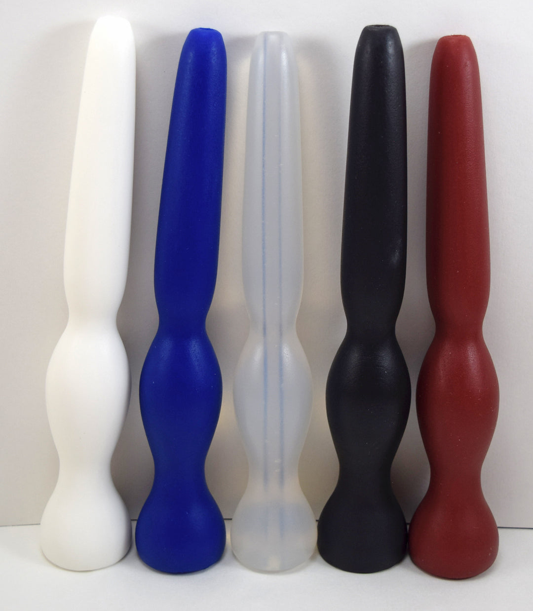 GRB35-9 tapered oval ball silicone enema colon nozzle lineup featuring white, blue, translucent, black, and red models with 1.4-inch retention balls, 9-inch total lengths, and 7.5-inch insertable depths.