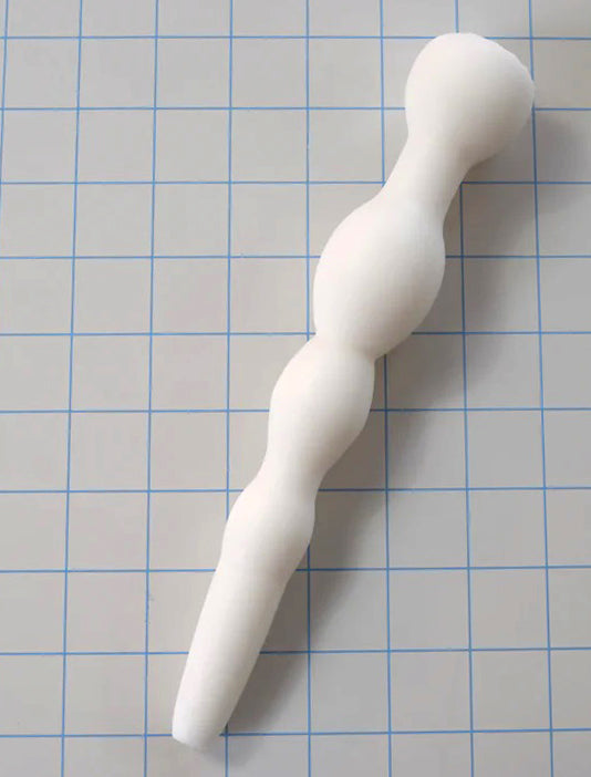 Angled top-down view of a white GRB 36 silicone retaining ball colon nozzle on a blue grid background.