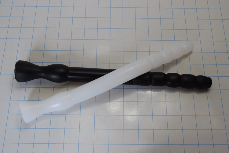 White and black GRB 75 flexible silicone colon tubes crossed over each other on a measurement grid demonstrating tip profiles.
