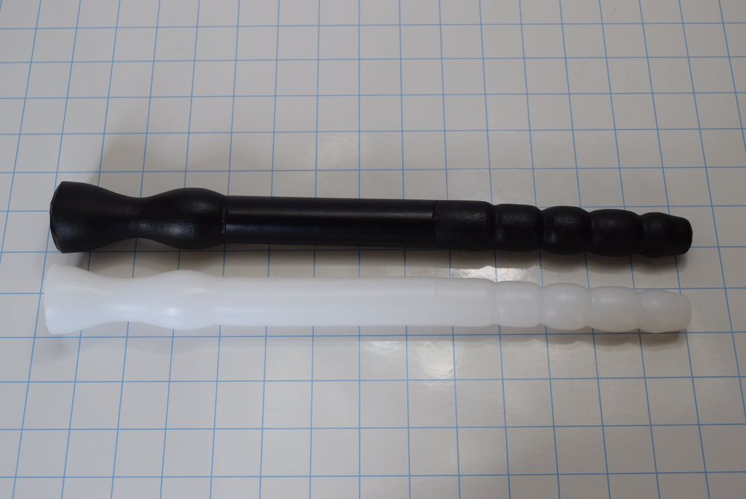 Black GRB 75 silicone colon tube with tapered Tip B and white GRB 75 with bumpy Tip A resting side-by-side on a blue grid.