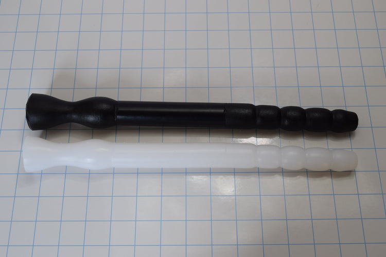 Black GRB 75 silicone colon tube with tapered Tip B and white GRB 75 with bumpy Tip A resting side-by-side on a blue grid.