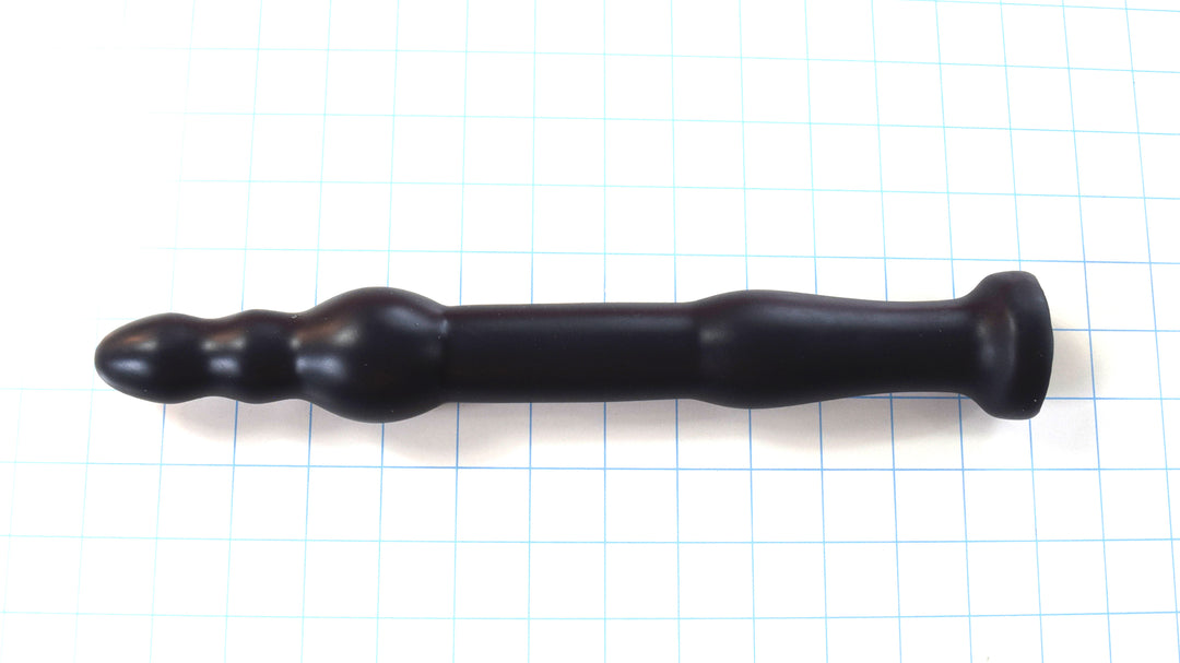 GRB 86 BT 12-inch silicone colon nozzle featuring a segmented ball-tip head with a 1.75-inch anchor ball, 1.3-inch main shaft, dual retention valleys, and a safety base flange on a blue grid background.