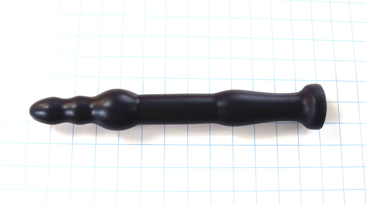 GRB 86 BT 12-inch silicone colon nozzle featuring a segmented ball-tip head with a 1.75-inch anchor ball, 1.3-inch main shaft, dual retention valleys, and a safety base flange on a blue grid background.