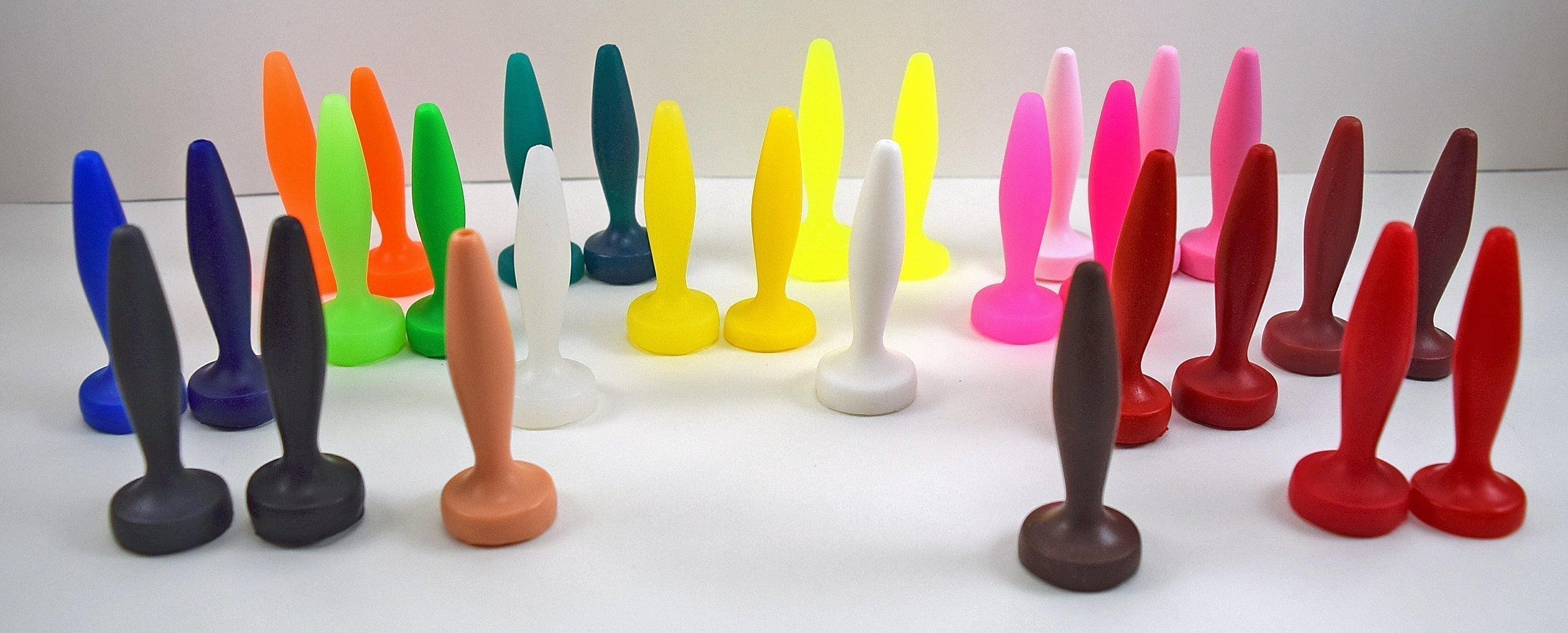 An array of handcrafted silicone nozzles and plugs displaying lighter and darker natural variations of each custom color.