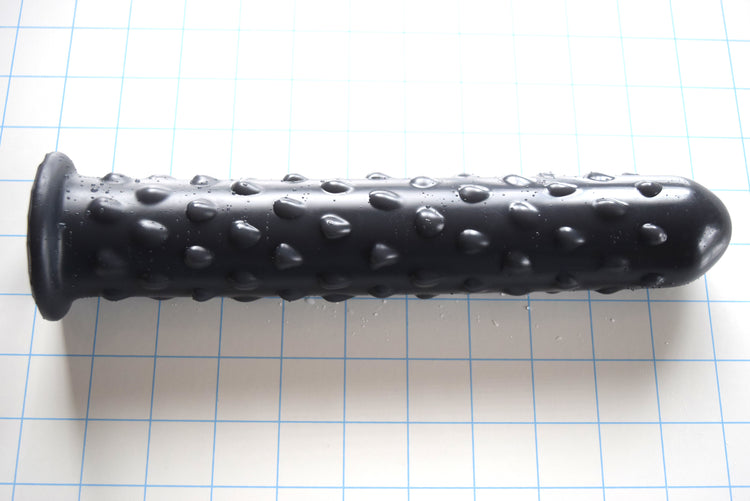 Black silicone Knobby Jumbo nozzle with textured surface, 1.75 inch diameter, and safety flange on a grid background
