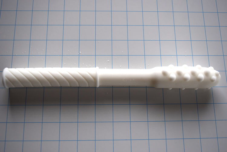 Knobby Tip textured translucent white silicone colon nozzle on a blue grid background, showcasing its 1.75-inch bulbous nodule tip, smooth mid-shaft, and diagonally ribbed base