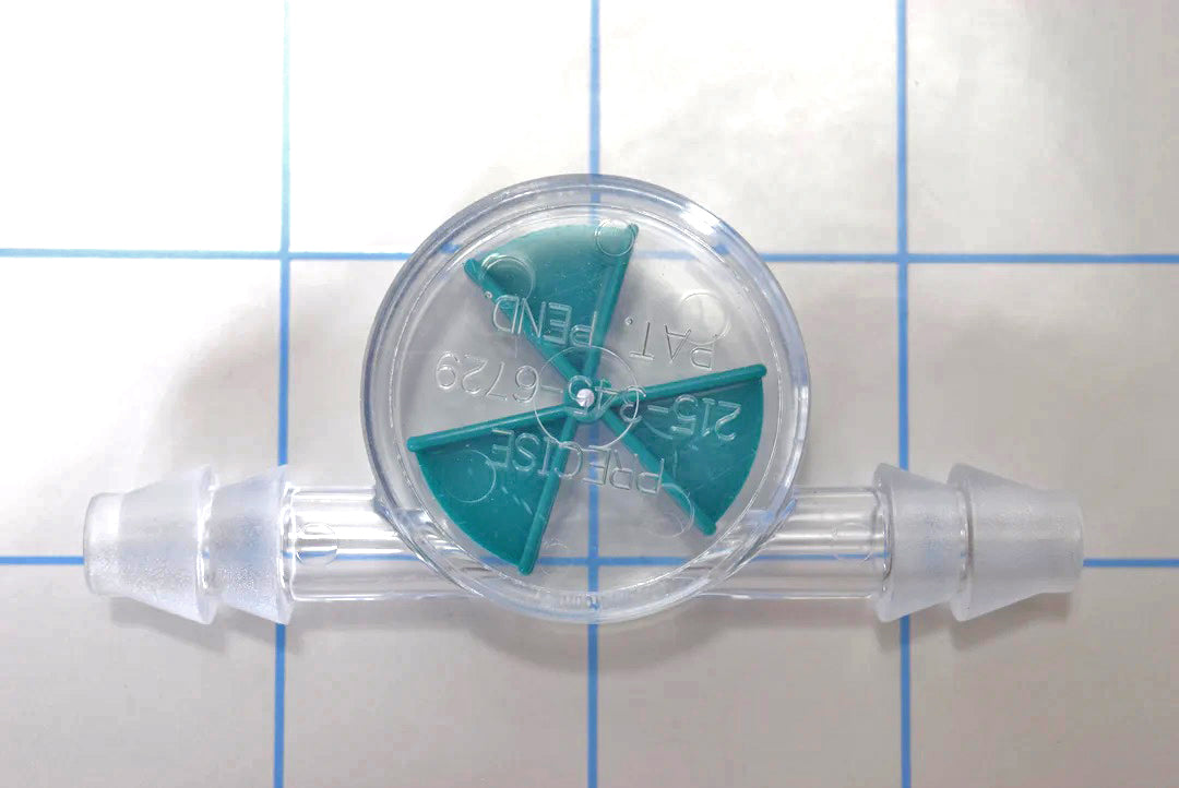 Close-up view of clear inline liquid flow indicator with a green wagon wheel spinner paddle and double barbed ends on a blue grid background.