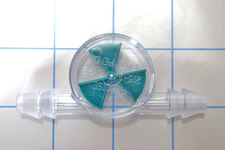 Close-up view of clear inline liquid flow indicator with a green wagon wheel spinner paddle and double barbed ends on a blue grid background.