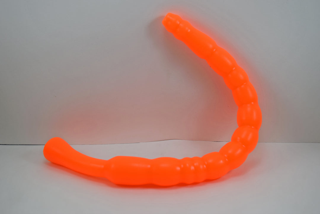Bright orange MBXL ribbed silicone colon nozzle, showcasing its flexible, graduated design and flared base flange on a clean white background