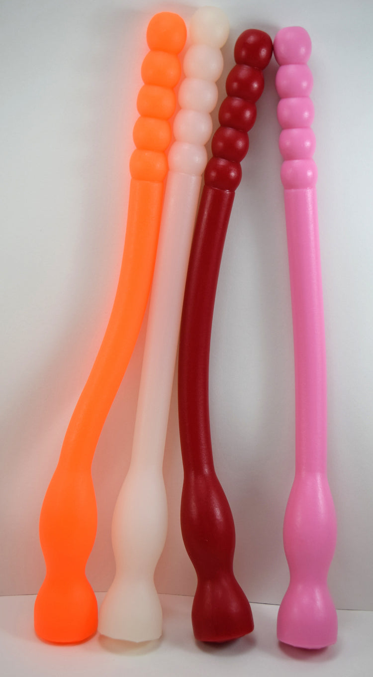 Four Model F flexible silicone colon tubes shown in orange, translucent-white, red, and pink, showcasing the 5-bead rolling ribbed tips, long smooth shafts, and integrated base retaining balls