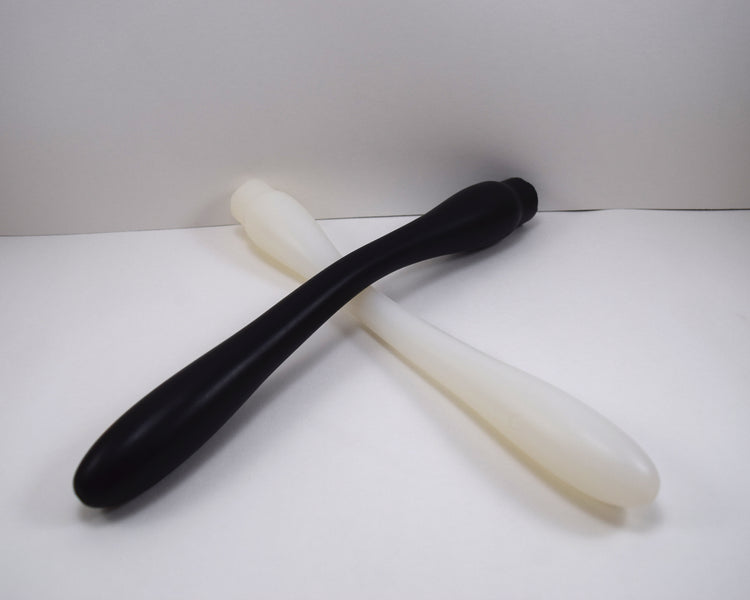 Two Model N 12-inch smooth bat-style silicone colon nozzles—one in solid black and one in translucent white—overlapping on a white background, highlighting the 1.25-inch oblong tip and 1-7/16 inch flared base