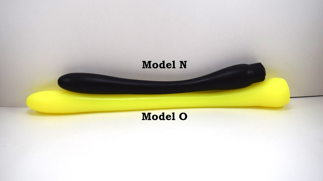 Black Model N silicone enema nozzle lying parallel to a longer yellow Model O nozzle on a white background.
