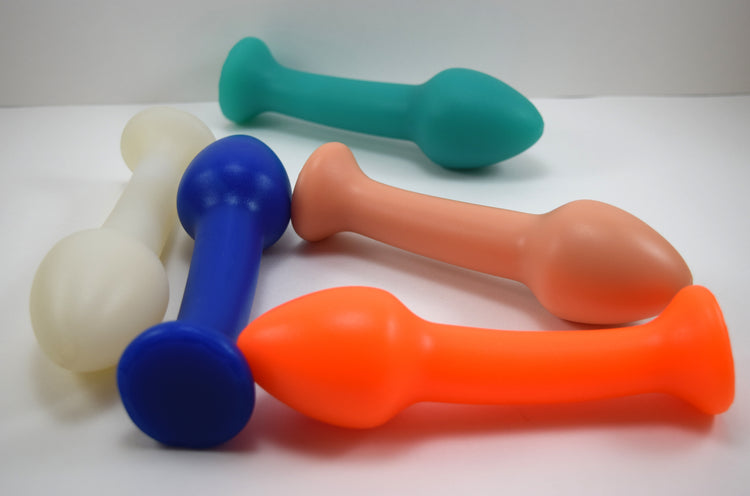 Group of Model Y 2-inch silicone enema nozzles in blue, orange, flesh, green, and translucent white displaying bulbous tips and anchoring shafts.