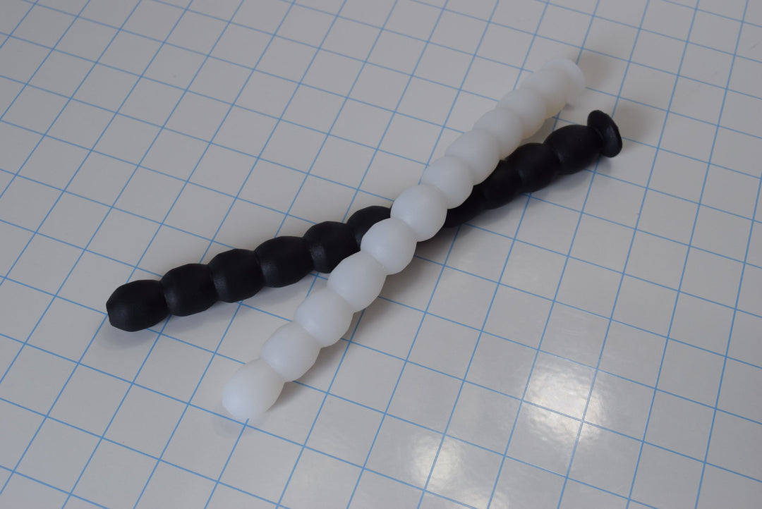 Multi Ball Shaft 9-inch silicone enema nozzle featuring 11 small ribbed balls for gentle, beginner-friendly insertion on a white grid background