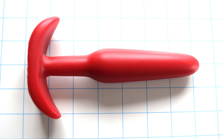 OF 1.3 red silicone retention enema nozzle showing its 1.3-inch maximum diameter shaft swell, 0.75-inch retention valley, and 4-inch wide ergonomic oval flange on a grid background
