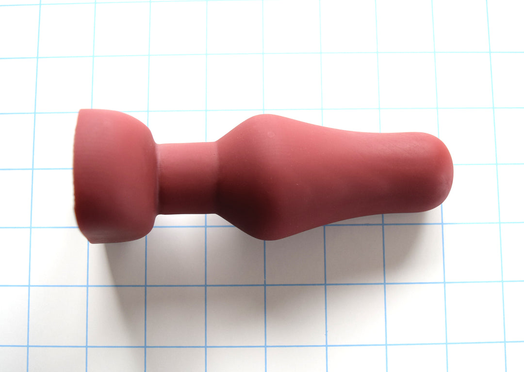 6-inch oval flange-style silicone enema nozzle with 1.9-inch maximum diameter swell, contoured oval flange, 4.5-inch insertable length