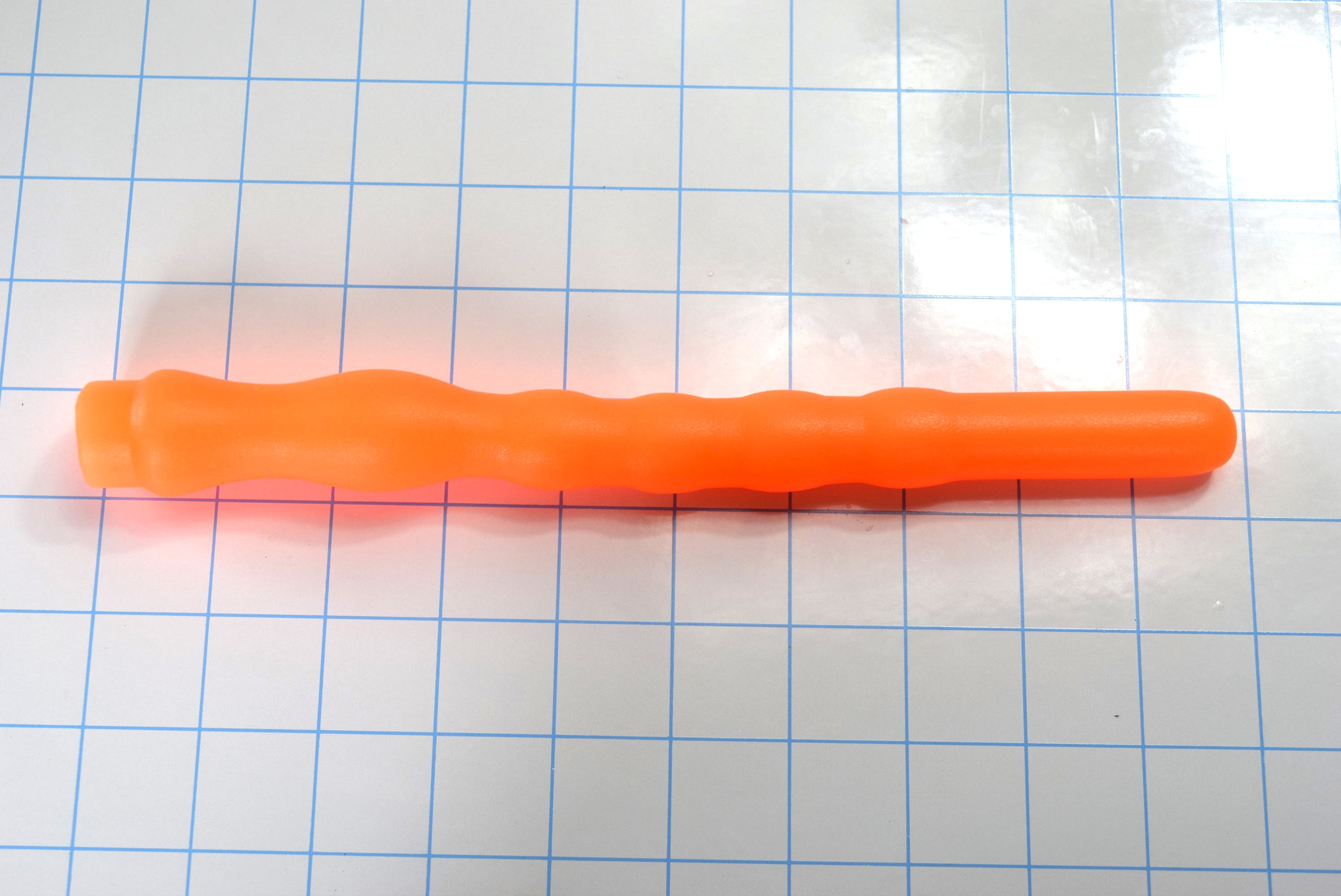 8 inch orange ribbed throat trainer silicone gag reflex device shown straight on grid background.