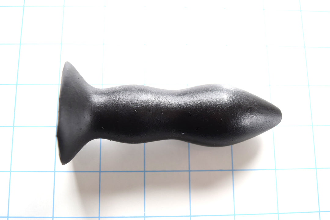 RTDL 1.3 black silicone rectal training dilator nozzle showcasing its 4.5-inch total length, 1.3-inch tapering ellipse tip, dual retention bulbs, and 1.75-inch safety base flange on a blue grid background