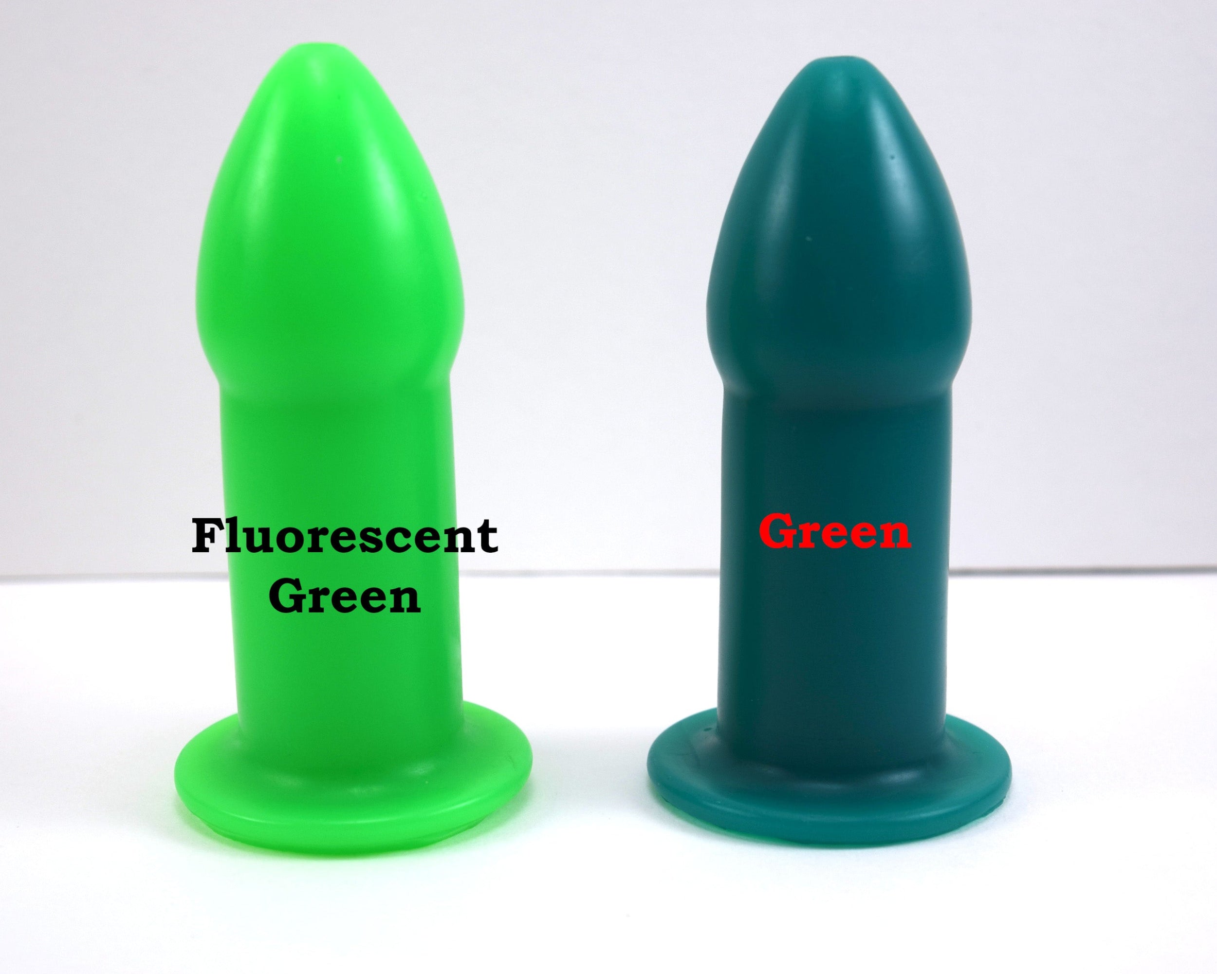 Fluorescent green and dark green silicone rectal training dilators standing side-by-side on a white surface with text.