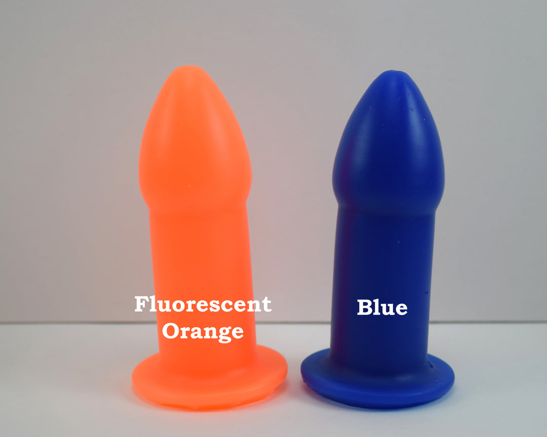 Fluorescent orange and blue silicone rectal training dilators standing side-by-side on a white surface with text overlay.