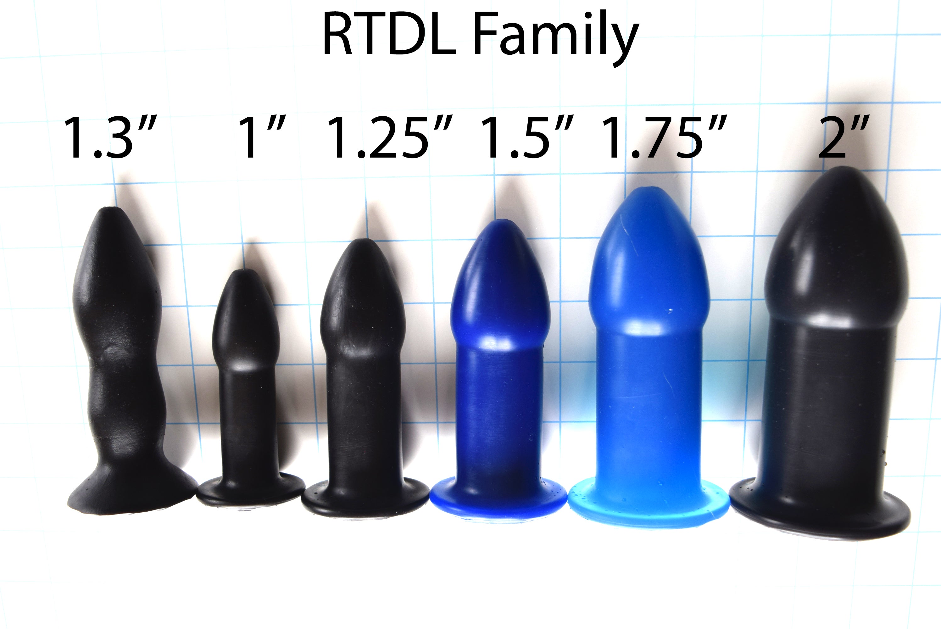 RTDL Family complete set of black silicone rectal training dilators standing upright in graduated sizes ranging from 1.3 inches to 2 inches, featuring tapered tips, smooth shafts, and safety flange bases on a grid background with size labels.