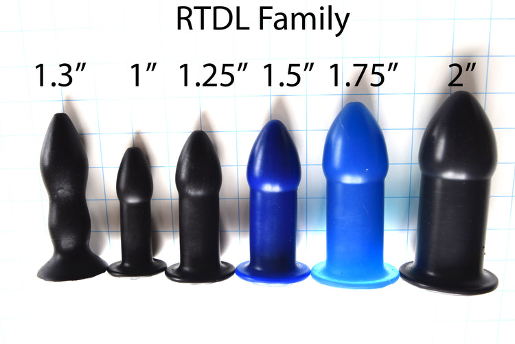 A row of six RTDL silicone retention enema nozzles in various sizes from 1 inch to 2 inches standing on a blue grid background.