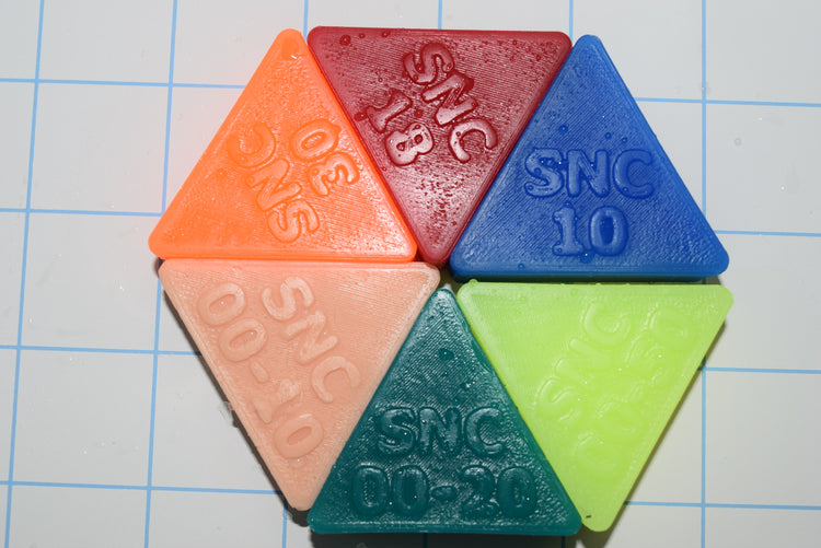 Close-up view of sample firmness triangles arranged in a circle, displaying embossed softness ratings from 00-20 up to 30.