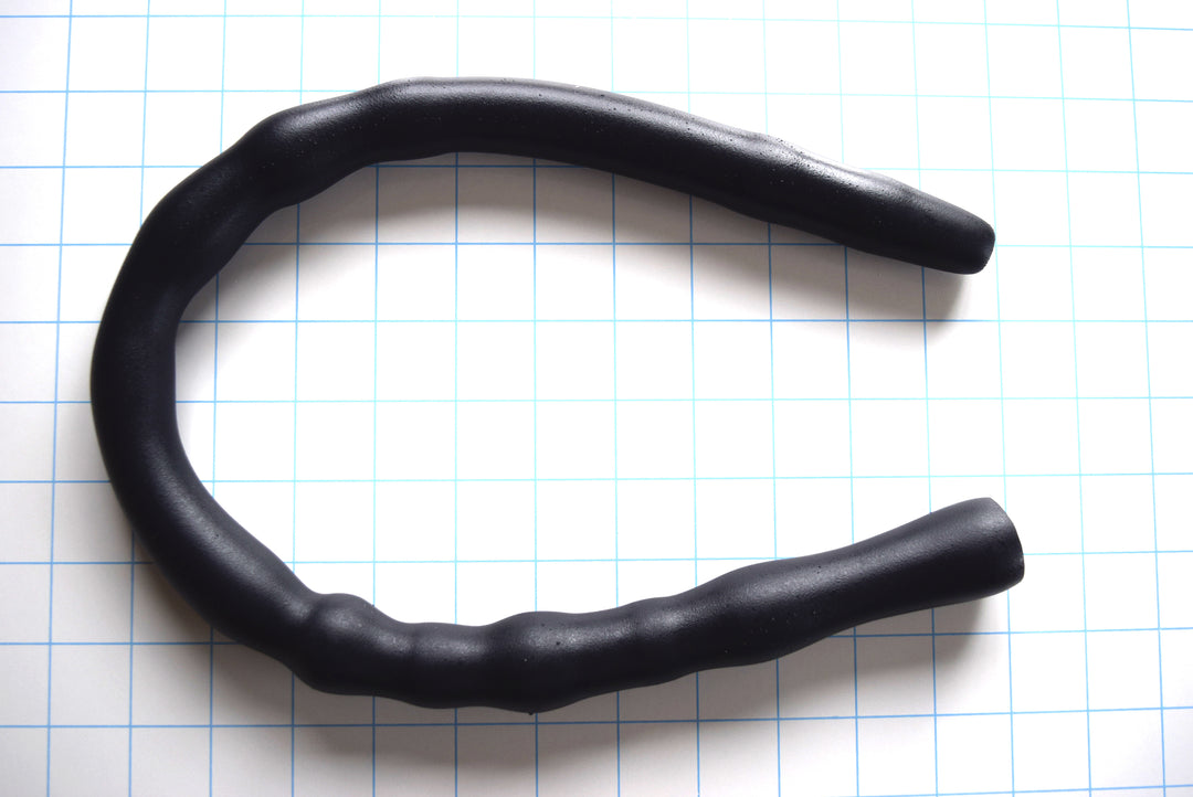 Black Shower Shooter 24-inch ribbed silicone nozzle with multi-ribbed texture, showing the 23-inch insertable length on a white grid background